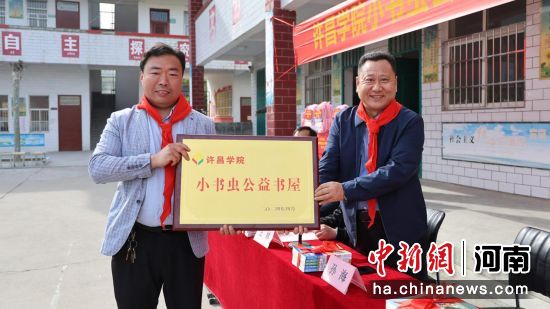图为买球的app排行榜前十名推荐党委副书记孙海(右1)将“小书虫”公益书屋的牌匾交到关爷庙小学校长杨少许手中。